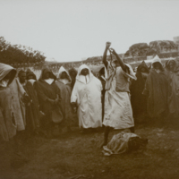 People gathered around snake charmer, 1891