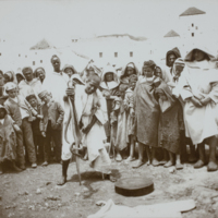 Group of people standing around snake charmer, 1891