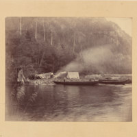 Camp near lakeshore, three people visible<br />
